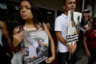Opositores venezolanos sostienen carteles con la imagen del líder opositor Leopoldo López en las afueras del Palacio de Justicia, durante el primer día del juicio en su contra el 23 de julio del 2014.