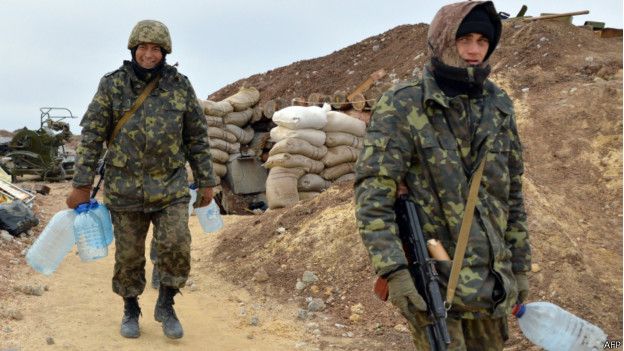 Soldados cargando botellas vacías de agua