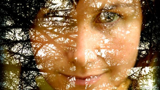 Un rostro fundido con una escena boscosa