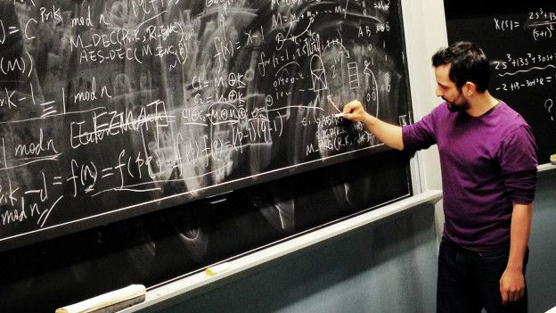 Un hombre escribe fórmulas matemáticas en una pizarra