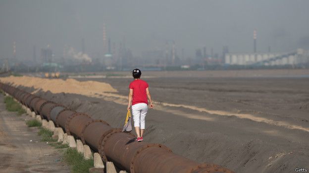 Mujer sobre una tuberia en el lago Baotou