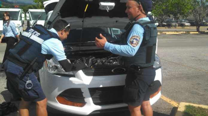 Policias Rescatan un gato del motor de un auto