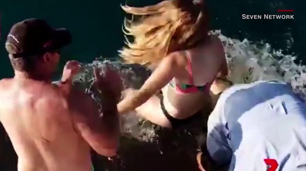  Video: Aterrador momento en que la mujer alimenta a los tiburones es arrastrada al agua 