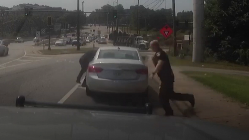 VIDEO: Se da a la fuga llev&aacute;ndose a un polic&iacute;a colgado de la ventanilla de su carro y lo arroja en la carretera 